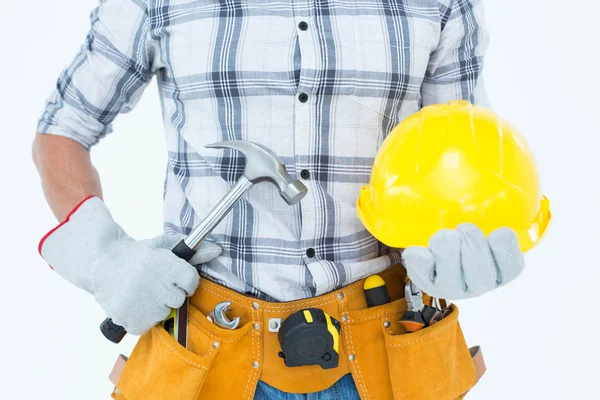 Handyman segurando martelo e chapéu duro — Fotografia de Stock