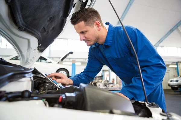 Mechanic Tablet PC gebruiken om op te lossen auto — Stockfoto