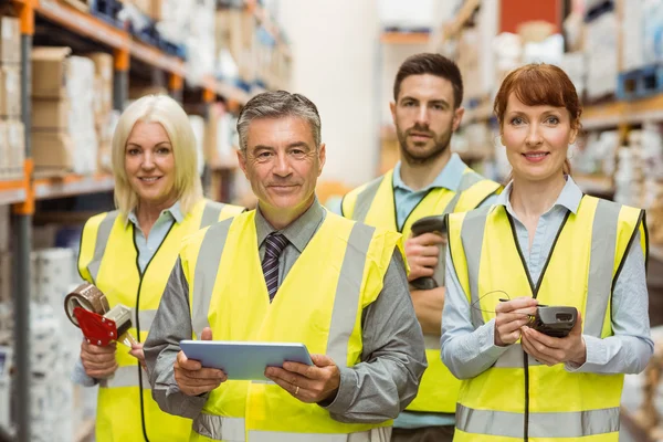 Equipo de almacén sonriente mirando la cámara — Foto de Stock