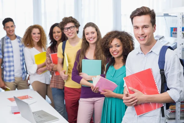 Students smiling at camera standing in a line — Stock Photo, Image
