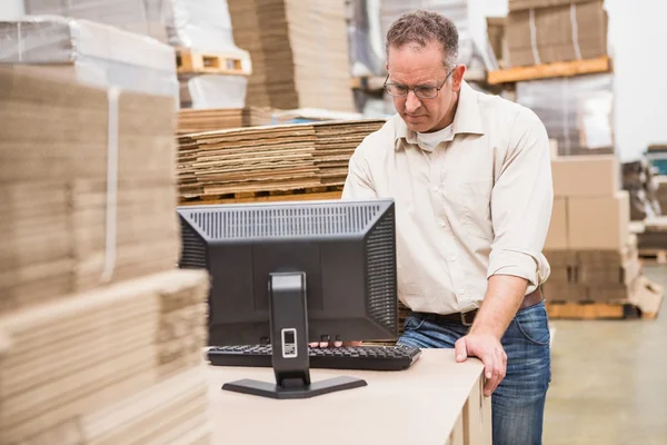 Travailleur d'entrepôt sérieux utilisant un ordinateur portable — Photo