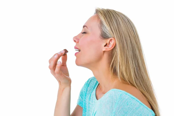 Pretty blonde eating chocolate — Stock Photo, Image