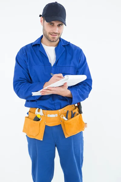 Repairman writing on document — Stock Photo, Image