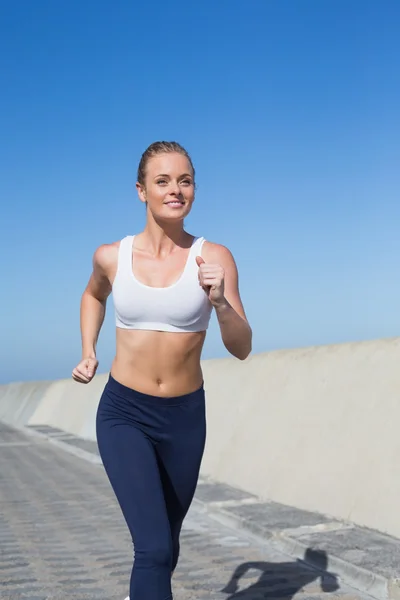 Fit blonde jogging on the pier — Stock Photo, Image