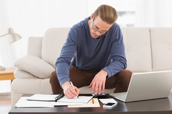 Homem concentrado usando calculadora contando suas contas — Fotografia de Stock