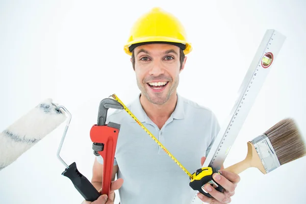 Happy worker holding various equipment — Stock Photo, Image