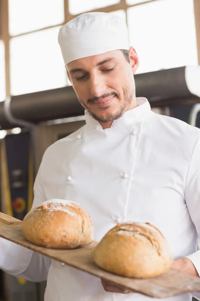 Baker showing tray of fresh bread — Stock Photo, Image