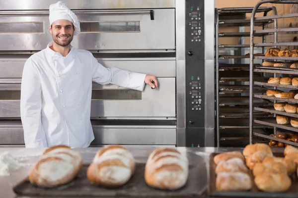 Baker leaning on professional oven