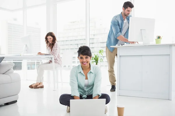 Empresária sentada no chão usando laptop — Fotografia de Stock