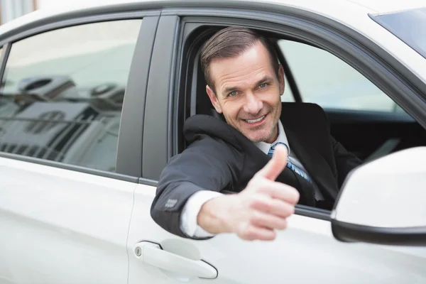 Empresario sonriendo a la cámara mostrando pulgares hacia arriba — Foto de Stock