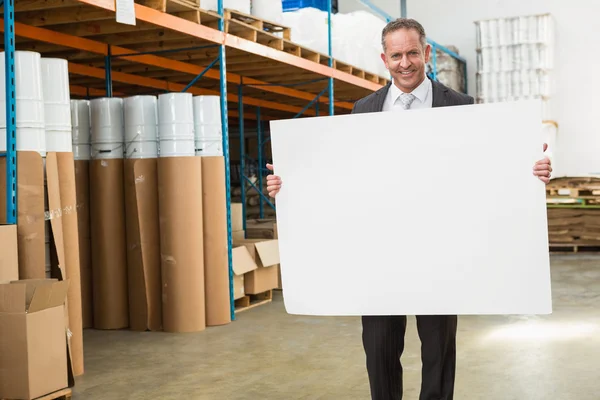 Gerente de armazém segurando cartaz branco — Fotografia de Stock