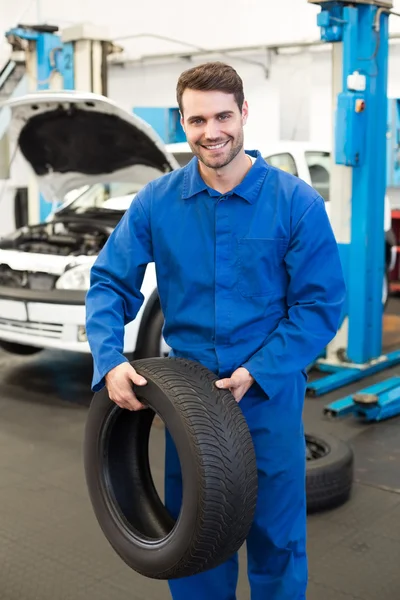 Mechanic holding a tire wheel — Stock Photo, Image