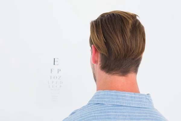 Homem focado em terno em letras de teste de olho — Fotografia de Stock