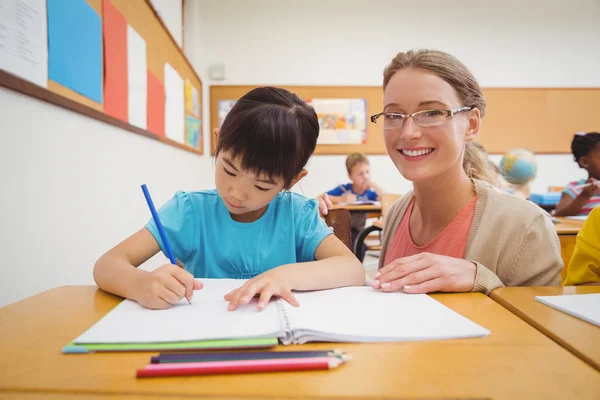 帮助学生在教室里的美女教师 — 图库照片