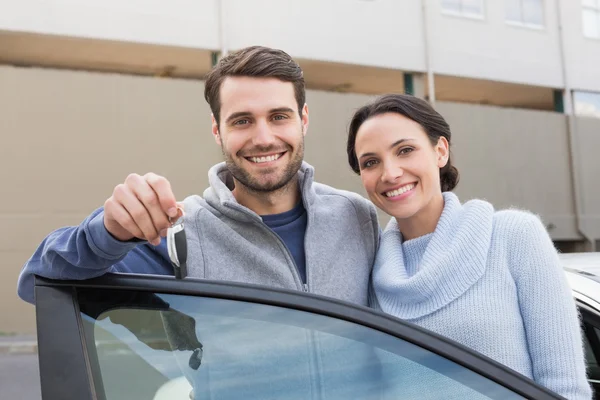 Young couple smiling holding new key — Stock Photo, Image