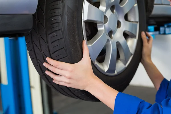 Mechanic adjusting the tire wheel — Stock Photo, Image