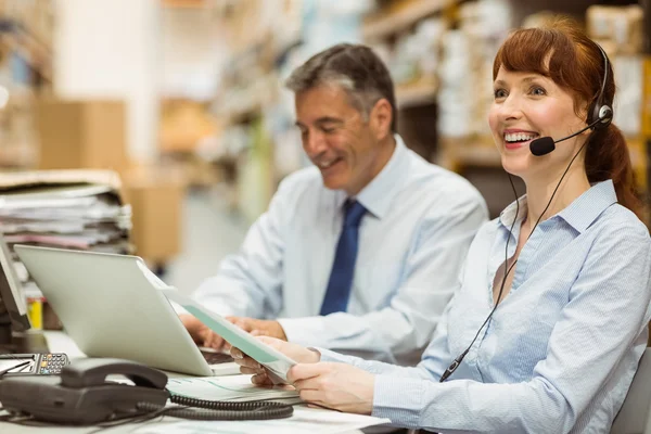 Lagerleiterin am Schreibtisch mit Headset — Stockfoto