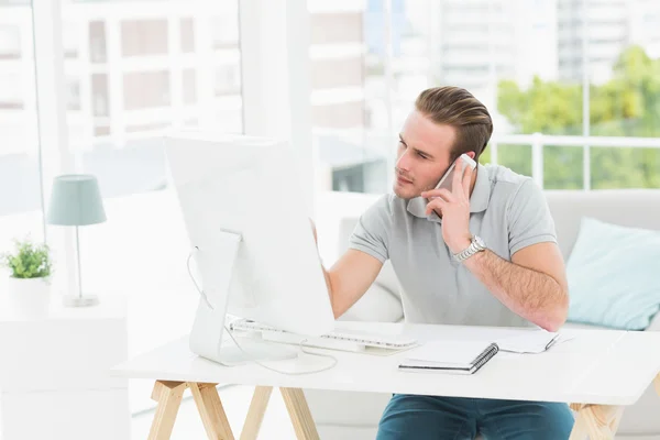 Businessman on phone using computer — Stock Photo, Image