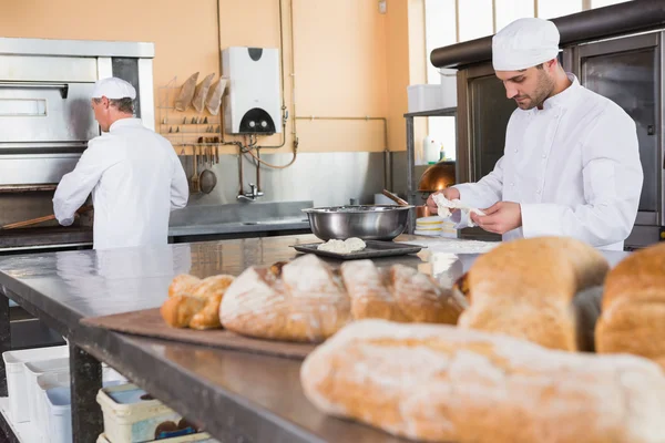 Baker fazendo massa na tigela de mistura — Fotografia de Stock