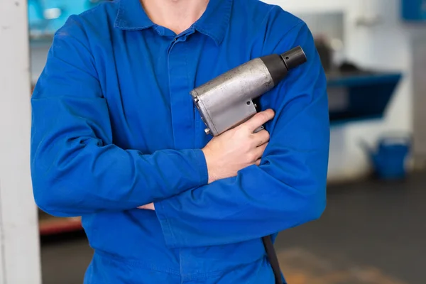 Mecánico sosteniendo una herramienta de taladro — Foto de Stock