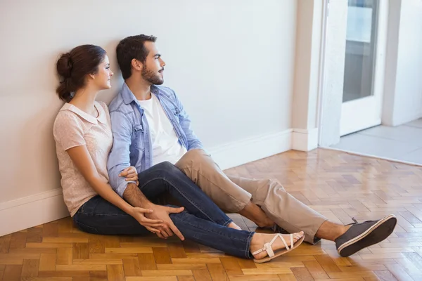 Couple sitting on floor against wall — Stock Photo, Image