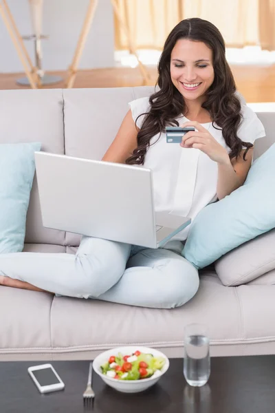 Brünette shoppen online auf der Couch — Stockfoto