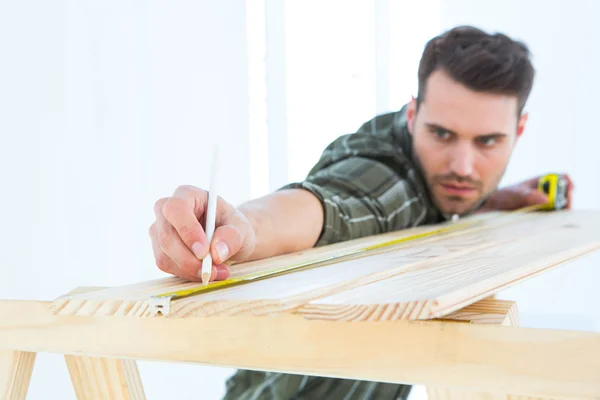 Worker marking on wooden plank — Stock Photo, Image