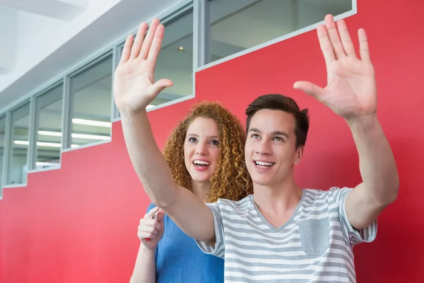 Smiling student gesturing with his friend — Stock Photo, Image