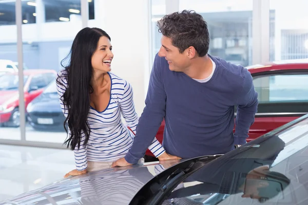 Pareja sonriente apoyada en el coche — Foto de Stock