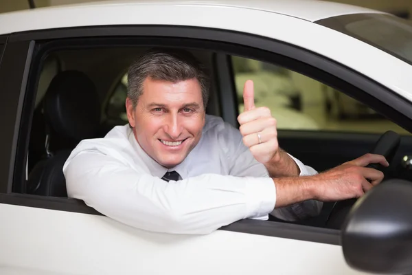 Lächelnder Mann sitzt in seinem Auto und gibt Daumen hoch — Stockfoto