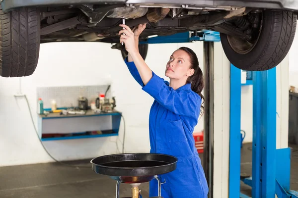 Mechanic adjusting something under car — Stock Photo, Image