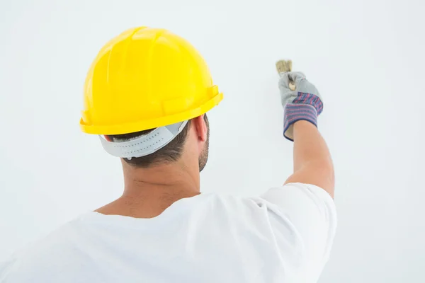 Man met helm tijdens het gebruik van penseel — Stockfoto