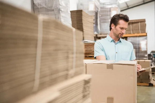 Warehouse worker checking his list on clipboard — Stock Photo, Image