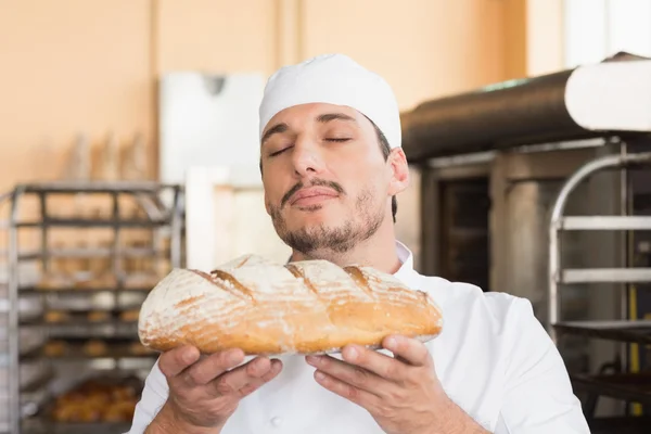 Baker smelling freshly baked loaf — Stock Photo, Image