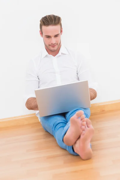 Mannen som sitter på golvet med bärbar dator — Stockfoto