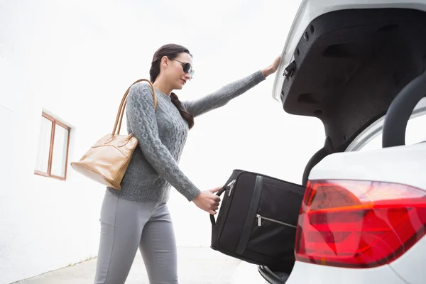 Frau zieht Gepäck aus dem Kofferraum ihres Autos — Stockfoto