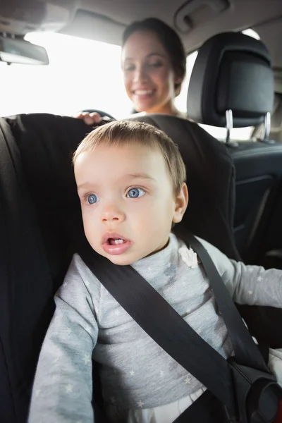 Mãe verificando seu bebê no assento do carro — Fotografia de Stock