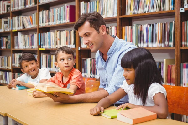 Carino alunni e insegnante di lettura in biblioteca — Foto Stock