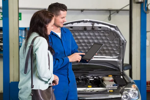 Mechanic showing customer problem with car — Stock Photo, Image