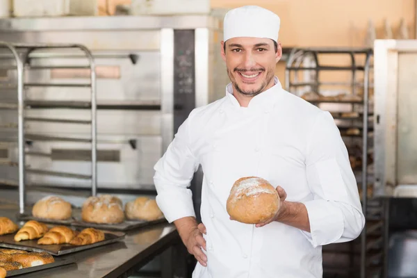 Baker holding a freshly baked loaf — Stock Photo, Image