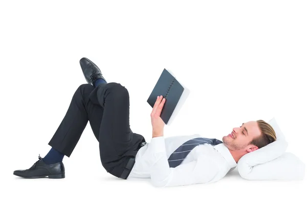 Relaxado homem de negócios mentindo e lendo livro — Fotografia de Stock