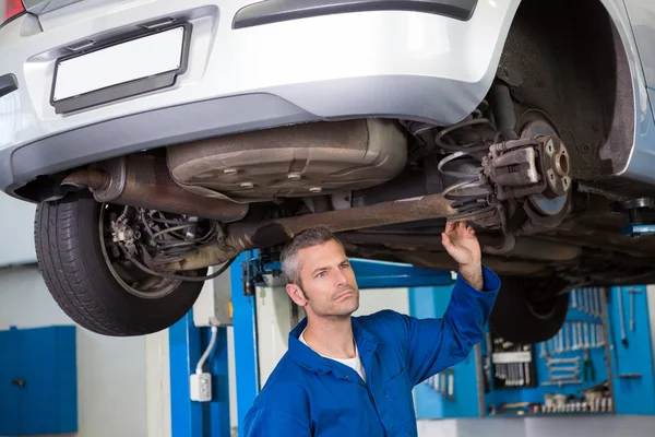 Mecánico examinando debajo del coche — Foto de Stock