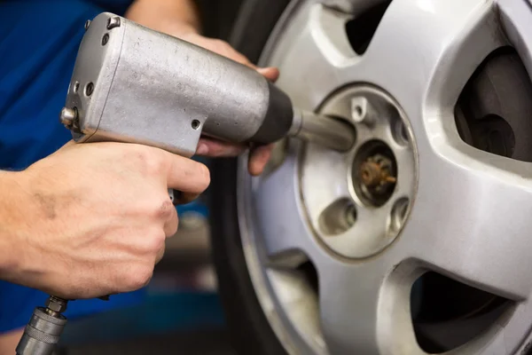 Mechanic adjusting the tire wheel — Stock Photo, Image