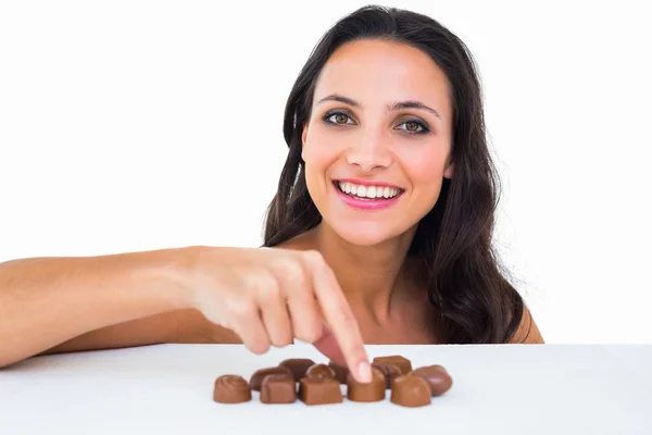 Bonita morena escogiendo chocolate —  Fotos de Stock