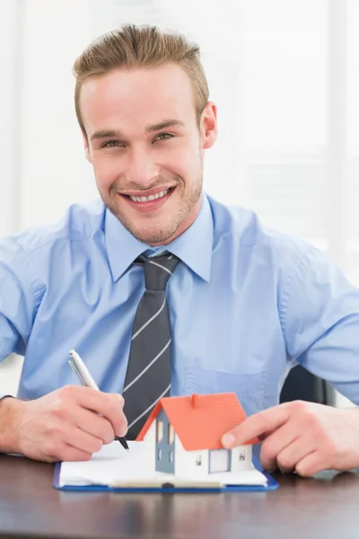 Empresário sorridente a tomar notas — Fotografia de Stock