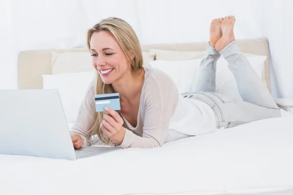 Shopping biondo online sul letto — Foto Stock