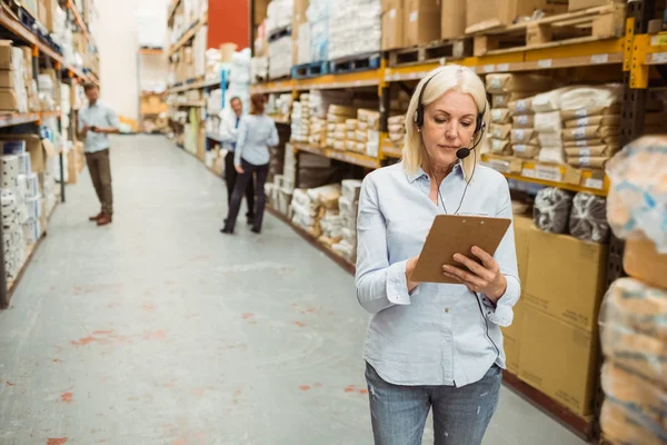 Focused warehouse manager writing on clipboard — Stock Photo, Image