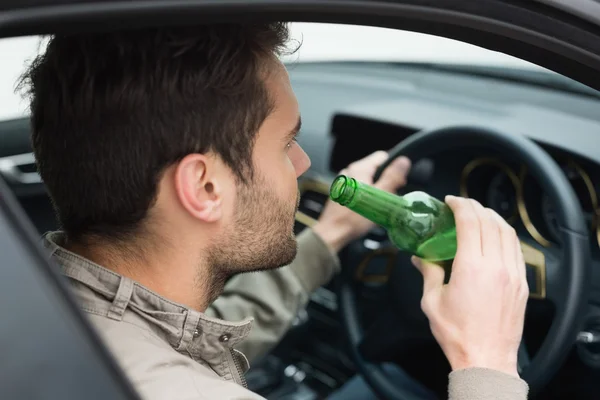 Hombre bebiendo cerveza mientras conduce — Foto de Stock