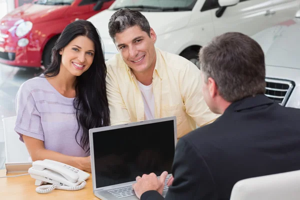 Couple souriant achetant une nouvelle voiture — Photo