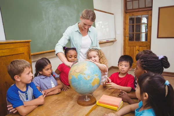 Lindos alumnos y profesor en el aula con globo — Foto de Stock